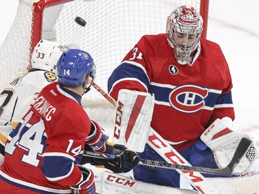 Montreal Canadiens goalie Carey Price makes a blocker save as teammate Tomas Plekanec checks Nashville Predators Colin Wilson during second period of National Hockey League game in Montreal Tuesday January 20, 2015.
