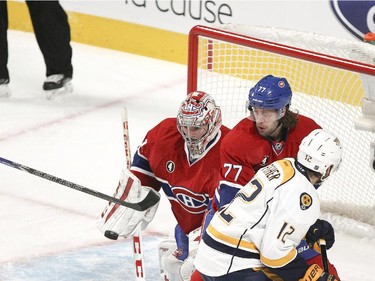 Nashville Predators Colin Wildon, left, swipes at the puck as Montreal Canadiens goalie Carey Price makes save while teammate Tom Gilbert holds off Predators Mike Fisher during first period of National Hockey League game in Montreal Tuesday January 20, 2015.