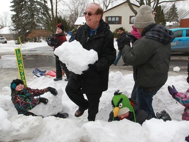Beaconsfield Mayor Georges Bourelle  helps move the snow fort away from the road.