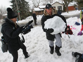 Yann Lefebvre carries a piece of snow up a hill away from the road in front of his house in Beaconsfield on Saturday, January 24, 2015.   Lefebvre was hosting a "moving party" to move the snow fort to another area of his lot. Early in the new year, Lefebvre built a snow fort in his front yard for his and other children to enjoy, but it wasn't long before he was contacted by the city and told to take it down. Mayor Georges Bourelle says the fort encroached on city property and poses a risk to both children and city workers.