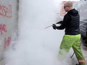 Corey Fleischer removes the word NAZI from a concrete wall in Montreal on Tuesday January 27, 2015.  Fleischer owns a small pressure-washing company, Provincial Power Washing, and for the past several years has been cleaning up hate graffiti in Montreal for free. He removes everything from swastikas to KKK symbols to hate messages on mosques.
