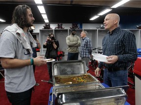 Alouettes head coach Tom Higgins (right) talks with quarterback Jonathan Crompton during a luncheon at Olympic Stadium where the coaching staff for the 2015 CFL season was announced.