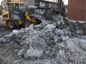 City of Montreal tractor pushes and lifts massive blocks of ice on Gilford st near Berri on Saturday January 31, 2015 following early morning water break  at the corner of Berri and St-Joseph