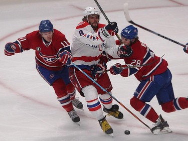 Washington Capitals' Alex Ovechkin, centre, goes through Montreal Canadiens' Brendan Gallagher, left, and Nathan Beaulieu, right, during first period NHL action in Montreal on Saturday January 31, 2015.