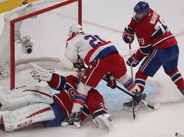 Washington Capitals right wing Troy Brouwer goes over Montreal Canadiens goalie Carey Price, with Andrei Markov looking on, during second period NHL action in Montreal on Saturday, January 31, 2015.