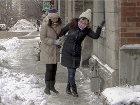 Rie Iku, left, steadies Yoko Mori as her friend loses her footing on the icy sidewalk on St. Urbain St. in Montreal Tuesday January 6, 2015.