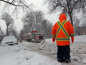 A snow removing crew works on Kensington Ave. in Montreal Jan. 7, 2015. Fresh snow was falling as the work went on in frigid temperatures.