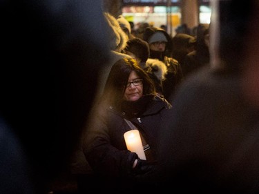 A woman stands solemnly as she takes part in a candle light vigil outside the French Consulate in Montreal on Wednesday January 7, 2015. Montrealers gathered in support of the victims of the terrorist attack on Charlie Hebdo in Paris earlier today that left 12 people dead and 11 injured.