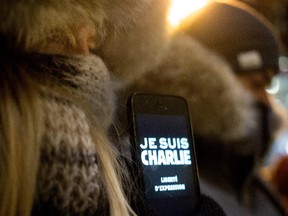 A women displays Je Suis Charlie as she participates in a candle light vigil outside the French Consulate in Montreal on Wednesday January 7, 2015. Montrealers gathered in support of the victims of the terrorist attack on Charlie Hebdo in Paris earlier today that left 12 people dead and 11 injured.