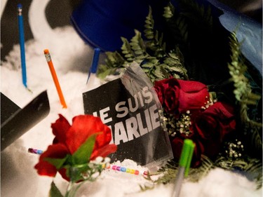 Pencils and flowers form a  small shrine in the snow during a candle light vigil outside the French Consulate in Montreal on Wednesday January 7, 2015. Montrealers gathered in support of the victims of the terrorist attack on Charlie Hebdo in Paris earlier today that left 12 people dead and 11 injured.