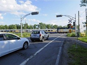 Cars wait for a train to pass at the level crossing where the lights have been installed by not yet activated in Terrasse-Vaudreuil.