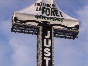 Six Greenpeace activists scaled the cross on Montreal's Mount Royal at 6 am, on Tuesday, March 18, 2014, and unfurled a large vertical banner that said "Justice?" The organization is asking Resolute Forest Products to work with Greenpeace in collaboration with other environmental groups to ensure that conservation and protection of the forests, animal habitats and first nations rights are respected.