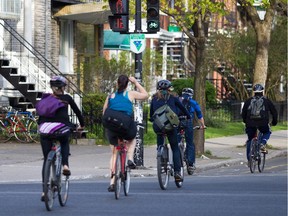 Cyclists ride on the bicycle path on Boyer street as they cross Jean Talon street in Montreal on Thursday, May 12, 2011. The city of Montreal announced it will invest another $10 million to expand the city's bike network.