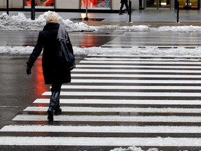 A pedestrian crosses  Réne Lévesque Blvd. in Montreal on Wednesday November 27, 2013.