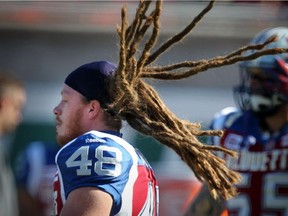 Alouettes linebacker Bear Woods flips his dreadlocks back in order to put his helmet on before game against the Saskatchewan Roughriders on Oct. 13, 2014 at Montreal's Molson Stadium.
