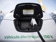 A 2012 Nissan Leaf with an electric power cord sits in the parking lot during a test drive session for the the EV 2012 Electric Vehicle trade show at the Circuit Gilles Villeneuve in Montreal on Tuesday, October 23, 2012.
