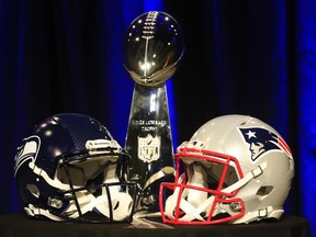 The Vince Lombardi Trophy is displayed between the helmets of the Seattle Seahawks and New England Patriots before a Super Bowl press conference on Jan. 30, 2015 in Phoenix, Arizona.