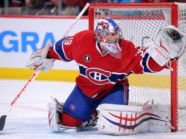 Joey MacDonald of the Montreal Canadiens makes a glove save on the puck during the warm-up period prior to game against the New York Islanders at the Bell Centre on Saturday, Jan. 17.