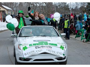 Montreal Gazette reporter Jason Magder, left, editor Brenda O'Farrell, centre, and reporter Kathryn Greenway wave to crowds lining Main Road  during the St Patrick's parade in Hudson in 2013.