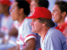 Manager Pete Rose of the Cincinnati Reds watches from the dugout during a game in 1985.