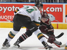 Michael McCarron of the London Knights takes faceoff against Josh Coyle of the Peterborough Petes during an OHL game at Budweiser Gardens on Dec. 14, 2014, in London, Ont.