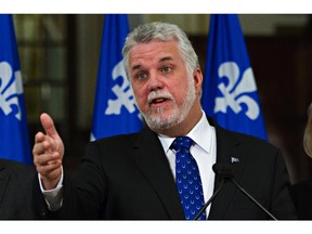 Quebec Premier Philippe Couillard gestures as he speaks to media after the second day of caucus meetings, Tuesday, Jan.27, 2015 at the Quebec legislature.