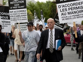Peter Sergakis (blue folder), supporters and employees of Brasserie Le Manoir march to Pointe-Claire city hall on August 15, 2011.