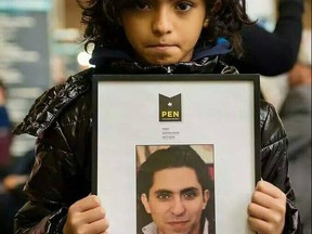 Terad Haidar holds a picture of his father, Raif Badawi. Raif Badawi, a blogger and activist who has a wife and three children in Sherbrooke, Que., underwent the first round of 50 lashes in public after morning prayers Friday, January 9, 2014 in Saudi Arabia, human rights group Amnesty International said. Badawi, who was arrested in 2012, is co-founder of a now banned website called the Liberal Saudi Network.