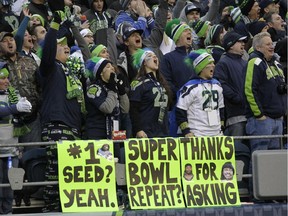 Seahawks fans cheer over signs predicting a second Super Bowl win for their team during game against the St. Louis Rams on Dec. 28, 2014, in Seattle.