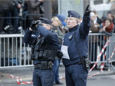 Security officers patrol at Republique square before the demonstration, in Paris, France, Sunday, Jan. 11, 2015. A rally of defiance and sorrow, protected by an unparalleled level of security, on Sunday will honor the 17 victims of three days of bloodshed in Paris that left France on alert for more violence.
