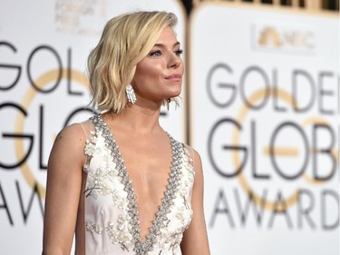 Sienna Miller poses in a Miu Miu gown at the 72nd annual Golden Globe Awards at the Beverly Hilton Hotel on Sunday, Jan. 11, 2015, in Beverly Hills, Calif.