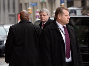 Prime Minister Stephen Harper is escorted by security as he arrives to the Langevin Block in Ottawa on Monday, January 12, 2015. As the prime minister and his cabinet craft the latest anti-terror legislation, they'll be thrust into a familiar balancing act between civil liberties and public safety.