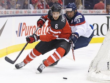 TORONTO, ON - JANUARY 4:  Shes Theodore #6 of Team Canada tries to avoid a checking Radovan Bondra #13 of Team Slovakia during a semi-final game in the 2015 IIHF World Junior Hockey Championship at the Air Canada Centre on January 4, 2015 in Toronto, Ontario, Canada.