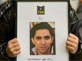 Terad Haidar holds a picture of his father, Raif Badawi. Amnesty International said Badawi a blogger and activist, underwent the first round of 50 lashes in public after morning prayers Friday, January 9, 2014 in Saudi Arabia. Badawi, who was arrested in 2012,  who has  a wife and three children in Sherbrooke, Quebec, is co-founder of a now banned website called the Liberal Saudi Network.