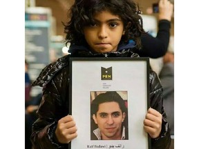 Terad Haidar holds a picture of his father, Raif Badawi. Amnesty International said Badawi a blogger and activist, underwent the first round of 50 lashes in public after morning prayers Friday, January 9, 2014 in Saudi Arabia. Badawi, who was arrested in 2012,  who has  a wife and three children in Sherbrooke, Quebec, is co-founder of a now banned website called the Liberal Saudi Network. (Facebook)