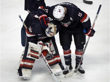 USA's goaltender Thatcher Demko is consoled by teammate John Hayden after their 3-2 loss to Russia in quarter-final hockey action at the IIHF World Junior Championship, Friday, January 2, 2015 in Montreal. Russia won the game 3-2 to advance to the semifinals.