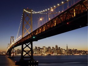 The San Francisco-Oakland Bay Bridge towers over the city skyline at dusk on Wednesday, Jan. 7, 2015, in San Francisco.