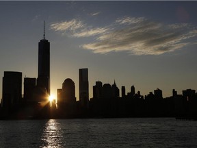 The sun rises next to One World Trade Center, Monday, Nov. 3, 2014 in this view from Jersey City, N.J.