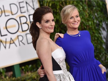 Tina Fey, left, and Amy Poehler arrive at the 72nd annual Golden Globe Awards at the Beverly Hilton Hotel on Sunday, Jan. 11, 2015, in Beverly Hills, Calif.
