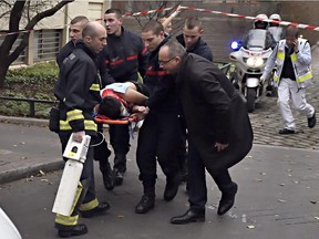 TOPSHOTS  A victim is evacuated on a stretcher on January 7, 2015 after armed gunmen stormed the offices of the French satirical newspaper Charlie Hebdo in Paris, leaving at least 11 people dead.