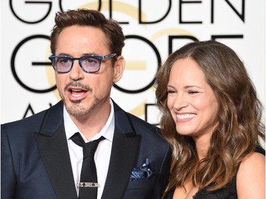 Producer Susan Downey (R) and actor Robert Downey, Jr. (L) arrive on the red carpet for the 72nd annual Golden Globe Awards, January 11, 2015 at the Beverly Hilton Hotel in Beverly Hills, California.