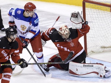Team Canada goaltender Zachary Fucale makes a save as Team Russia's Pavel Buchnevich looks for the rebound makes during first period gold medal game hockey action at the IIHF World Junior Championship in Toronto on Monday, Jan. 5, 2015.