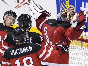 Canada goalie Zachary Fucale, right, reacts with teammates after defeating Slovakia during third period semifinal hockey action at the IIHF World Junior Championships in Toronto on Sunday, January 4, 2015.