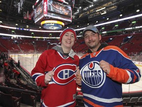 Montreal Canadiens fan Liz Gomes and her husband, Bryan, an Edmonton Oilers fan, show off their duelling team's jerseys prior to the Habs-Oilers game in Montreal on Thursday February 12, 2015.  The Edmonton residents were in Montreal to see two Canadiens games.