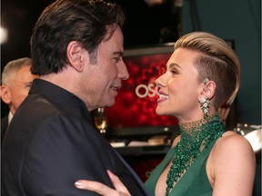 John Travolta and Scarlett Johansson embrace backstage during the 87th Annual Academy Awards at Dolby Theatre on February 22, 2015.