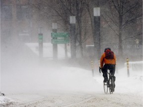 A cyclist braves cold temperatures as a winter storm hits the area, Monday, Feb. 2, 2015, in Montreal.