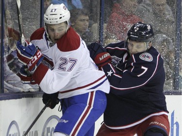 Montreal Canadiens' Alex Galchenyuk, left, and Columbus Blue Jackets' Jack Johnson fight for a loose puck during the first period of an NHL hockey game Thursday, Feb. 26, 2015, in Columbus, Ohio.