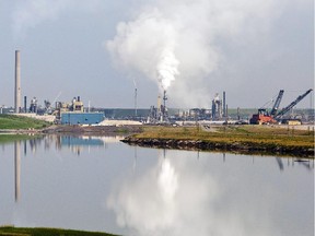 An oil sands facility is reflected in a tailings pond near Fort McMurray, Alta., on July 10, 2012.