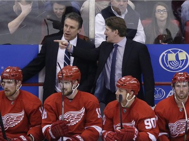 Detroit Red Wings head coach Mike Babcock, right, talks with assistant coach Andrew Brewer during the third period of an NHL hockey game against the Montreal Canadiens, Monday, Feb. 16, 2015 in Detroit. Montreal defeated Detroit 2-0.