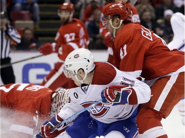 Montreal Canadiens right wing Brendan Gallagher (11) defended by Detroit Red Wings right wing Luke Glendening (41) shoots towards goalie Jimmy Howard during the first period of an NHL hockey game Monday, Feb. 16, 2015, in Detroit.